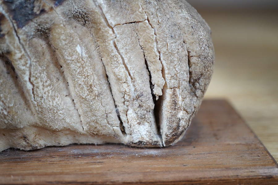 A junior Woolly mammoth tooth, mounted, 14cm excluding base. Condition - crack to one side, requires filling